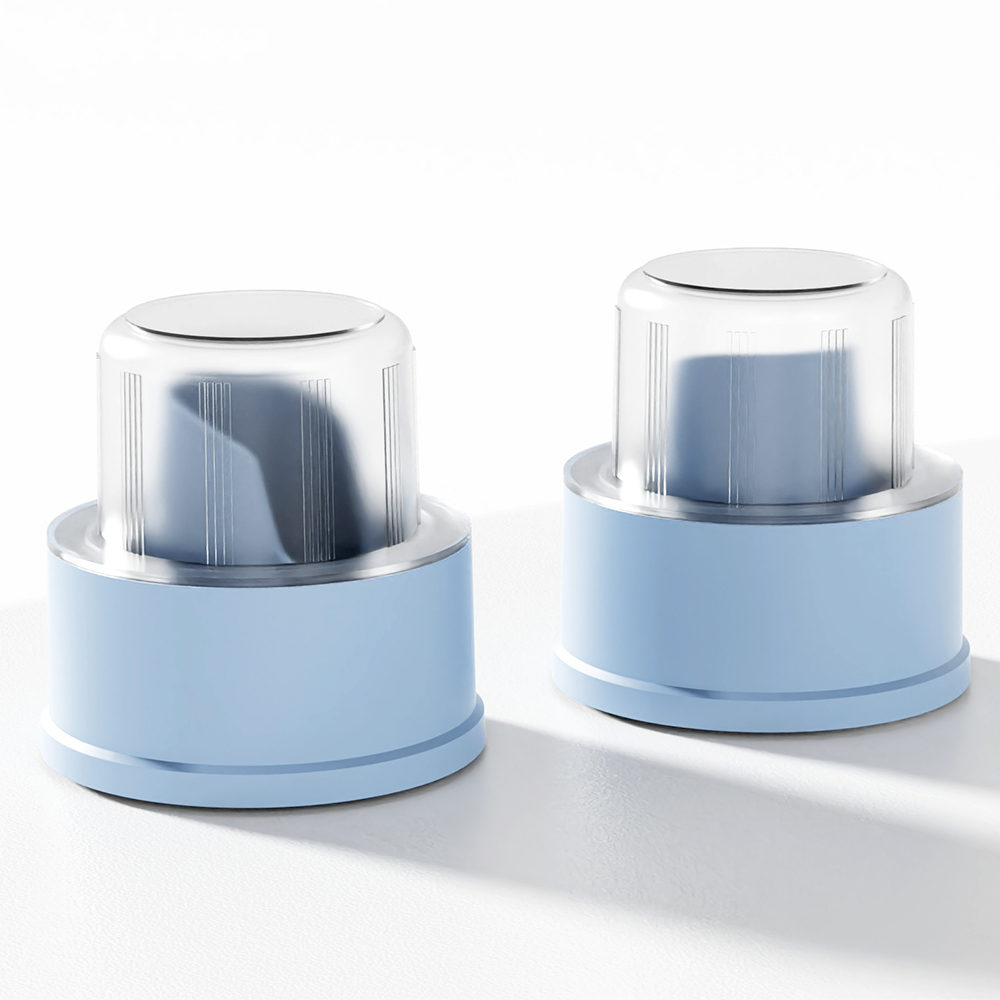 Two light blue cylindrical containers with silver lids, resembling laundry detergent caps, sit on a white surface.