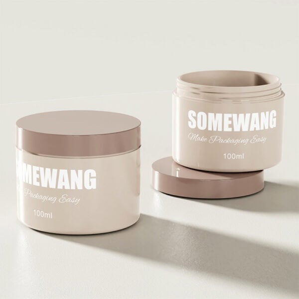 Two beige AS-JP100AC 100g PP cream jars with brown lids labeled "Somewang Make Packaging Easy" sit on a light surface. One is open.