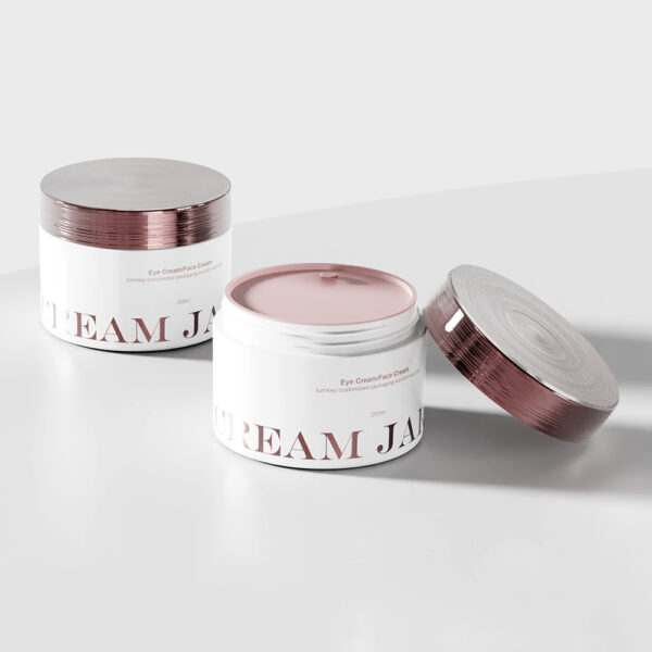 Two jars of eye cream with bamboo lids rest on a white surface, displaying luxurious pink contents and durable double-wall design.