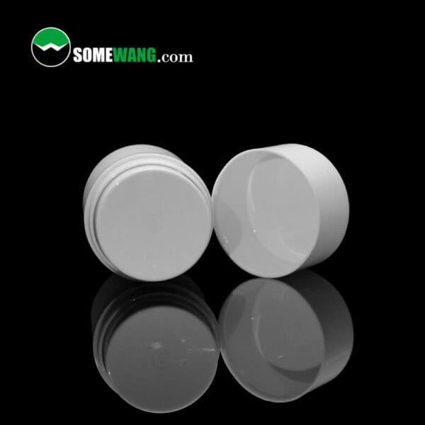 Two white SWC-BPA70B Cost Effective PP Essential Oil Airless Pump Bottle lids with a reflective surface, displayed on a black background, featuring the text "somewang.com".