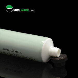 Ống nhựa nhiều lớp bằng nhôm mềm 80ml 100ml có nắp hồi màu đen, được dán nhãn "hòa bình&tinh khiết", phản chiếu trên bề mặt tối màu với hình mờ "somewang.com".
