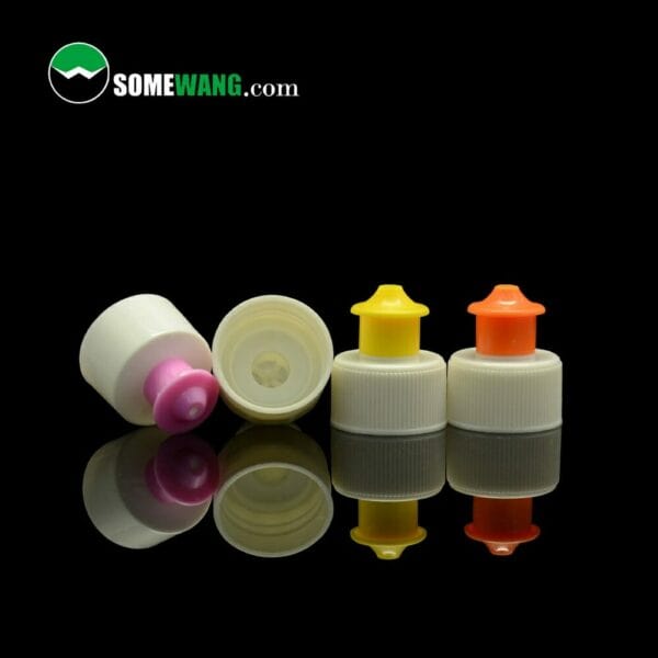 A variety of small plastic bottles with different colored pull-push caps and nozzles on a reflective surface, labeled "pull push cap for detergent washing or water bottle" from somewang.com.