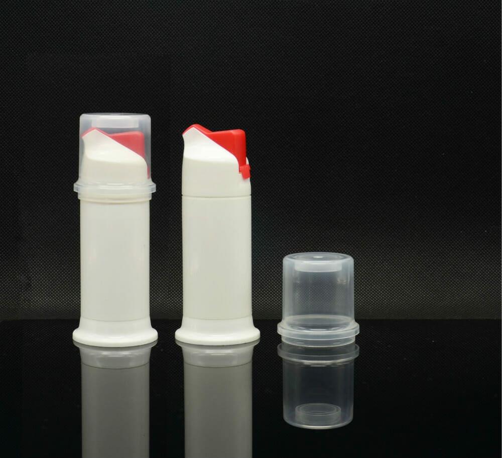 Two Novel Design Plastic PP Material Toothpaste Airless Bottles Wholesale with red caps on a reflective surface against a black background.