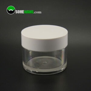 A clear SWC-JBG100B 100g PETG cream jar with a white screw-on lid on a reflective black surface, displaying the URL "somewang.com" in the background.