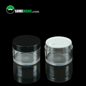 Two transparent SWC-JBG100C 100g PETG Cream Jars with black lids on a reflective surface, one open with visible white cream, and the logo "somewang.com" at the top.