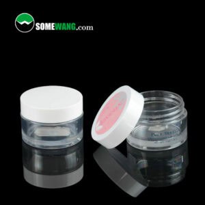 Two transparent SWC-JBG30B nice quality 30g PETG Jars with white lids on a reflective surface, one closed and labeled "lovely", the other open displaying a label "pure vanilla".