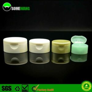Quatro frascos de cosméticos em diferentes tonalidades, sendo um deles com tampa de shampoo de plástico PP flip-top, exibindo um produto verde claro sobre um fundo escuro com bordas iluminadas.