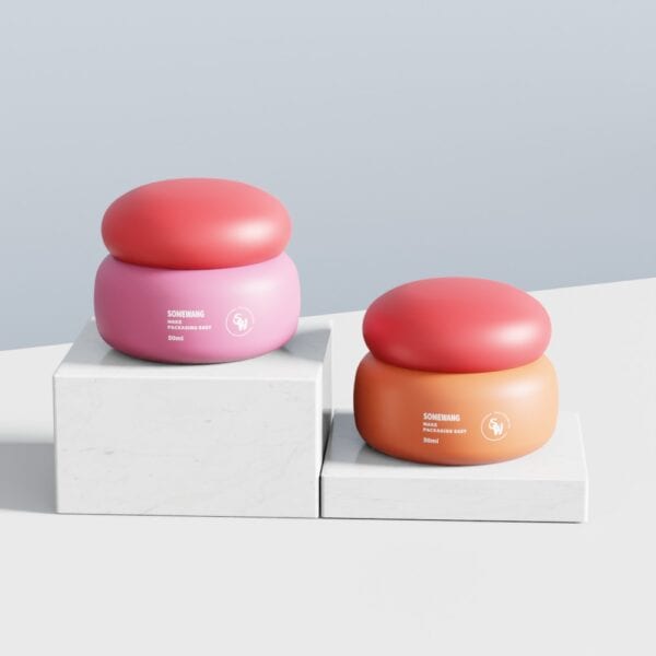 Potes de creme de cogumelo SWC-JP50SS rosa e laranja com tampas vermelhas em blocos de mármore branco sobre um fundo simples.
