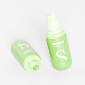 Hai chai màu xanh lá cây thanh lịch dung tích 30ml có chữ màu trắng và bơm không khí: một chai thẳng đứng, chai còn lại mở nắp.