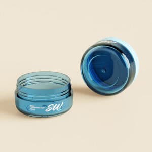 Hai lọ nhựa màu xanh (10ml & 20ml) có chữ và logo màu trắng trên bề mặt màu be; một lọ thẳng đứng, một lọ mở. Hoàn hảo cho kích thước du lịch.