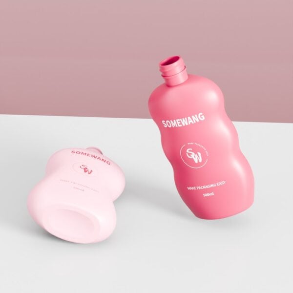 분홍색 물결 모양의 500ml 바디로션 병 두 개가 흰색 표면에 놓여 있으며, 한 병은 세워져 있고, 다른 한 병은 눕혀져 있습니다.