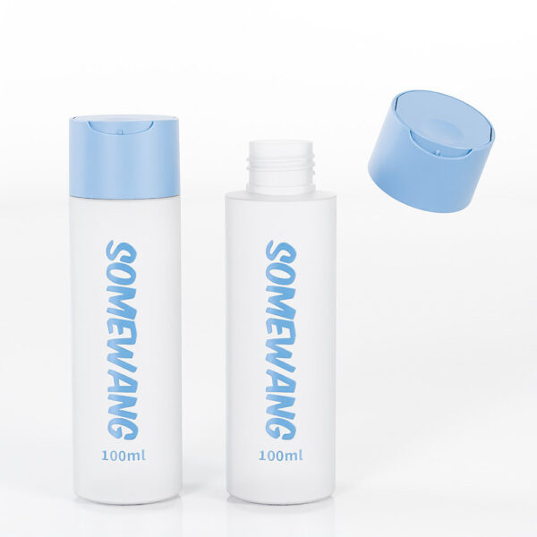 Two white 100ml flat shoulder bottles with blue caps; labeled for beauty industry. One cap is off and floating.