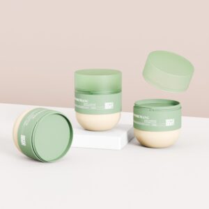 Tres frascos de mascarilla capilar PET de 270 ml: uno abierto, otro cerrado y otro con su tapa verde flotando sobre la base beige.