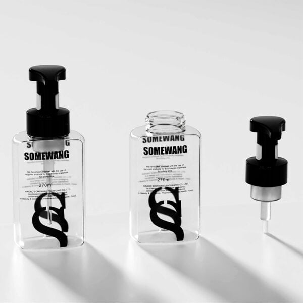 Three sleek, transparent "SOMEWANG" lotion bottles with black pumps exemplify elegant design on a white surface.