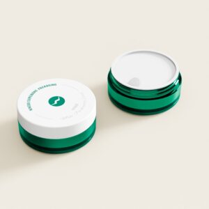 Zwei grüne PETG-Cremetiegel (30 g und 60 g) stehen auf Beige; einer ist geschlossen, einer ist offen und zeigt die weiße Innenversiegelung.