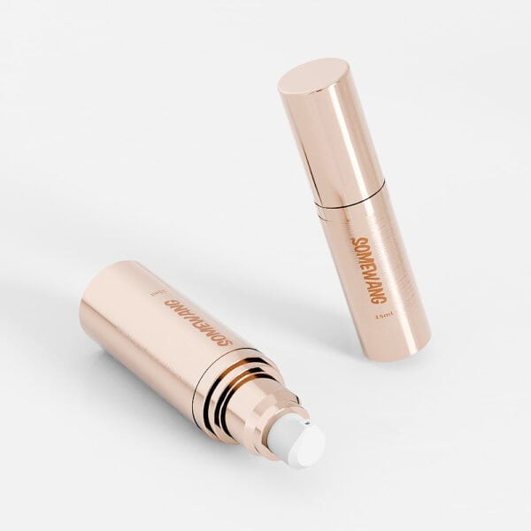 On a pristine white backdrop, two elegant gold Cosmetic Pump Bottles (15ml-100ml) are displayed—one capped upright, one uncapped. Perfect for premium skincare.