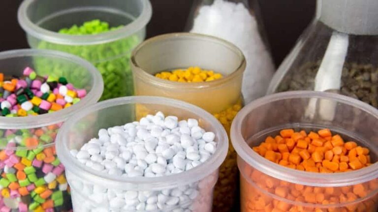 مجموعة متنوعة من الأوعية البلاستيكية المملوءة بخرز بألوان متنوعة. هذه الأوعية شفافة، مما يسمح للمشاهد برؤية تشكيلة الخرز بداخلها، والتي تأتي بألوان متنوعة، منها الأخضر والأصفر والأبيض والبرتقالي. تتنوع أحجام وأشكال الخرز، والأوعية مرتبة على طاولة، مما يخلق عرضًا ملونًا ومنظمًا.