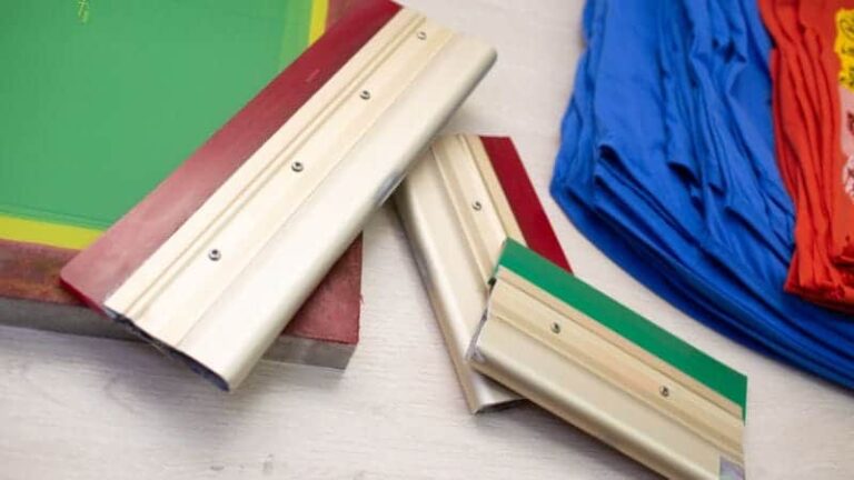 هناك ثلاث كتل خشبية مطلية بألوان مختلفة، مثبت عليها شرائط معدنية، يمكن استخدامها لتثبيت الشاشات أثناء عملية الطباعة الحريرية. خلف هذه الكتل، توجد عناصر مرئية جزئيًا، قد تكون قطعًا من القماش أو البلاستيك باللونين الأزرق والأحمر، ربما تُمثل المواد المراد طباعتها باستخدام أحبار البلاستيسول.