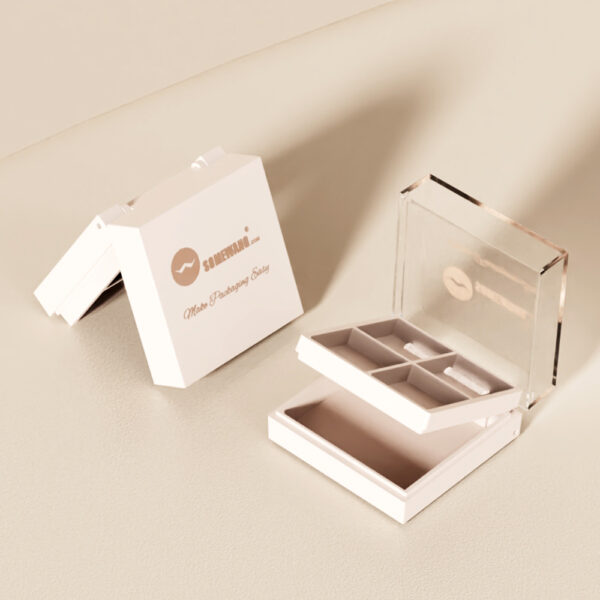 Una paleta de sombras de ojos de 4 colores abierta con una tapa transparente se encuentra junto a su caja cerrada de marca sobre una superficie clara.