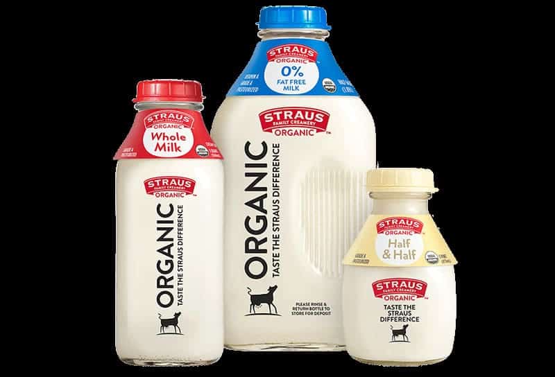 Tres botellas de productos lácteos orgánicos straus, que incluyen leche entera, leche descremada y half & half.