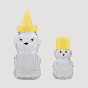 Hai chai nhựa PET 45ml/120ml có hình con gấu, một chai có nắp vòi màu vàng và một chai có nắp phẳng màu vàng, trên nền trắng.