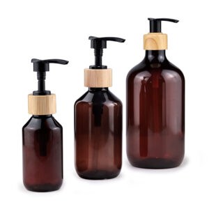 Three 24ml amber PET pharmaceutical bottles with black and yellow pumps, isolated on a white background.