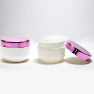Tres Frascos de PP de 200ml para cuidado personal con tapas metálicas de color rosa sobre fondo blanco, la tapa del frasco del medio está abierta mostrando su contenido.
