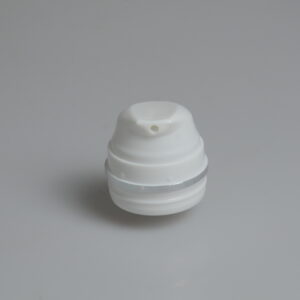 Una tapa de plástico blanca con un orificio central encaja perfectamente en una botella sin aire con boca de salida redonda de 30-150 ml, colocada sobre una superficie gris claro.