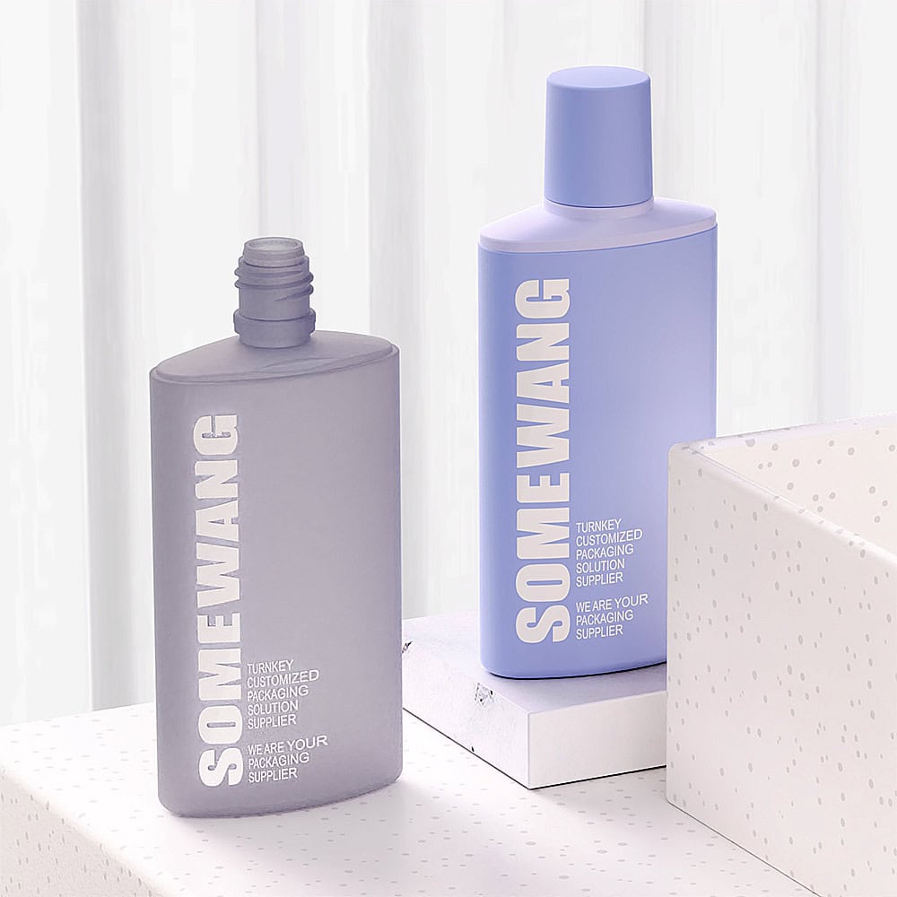 Two bottles of Somewang auto-draft beauty products on a white surface against a window with sheer curtains. One is grey and one is lavender, both with minimalist design.