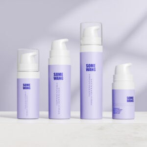 Cuatro botellas sin aire de PP color lavanda (10 ml, 15 ml, 20 ml) con tapas blancas con la etiqueta "SOME WANG" sobre un fondo violeta claro.