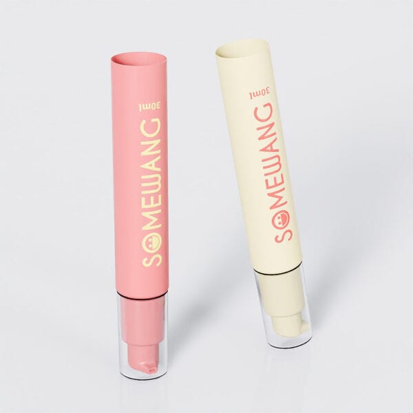 Two 30ml "SOMEWANG" cylindrical lotion bottles, pink and beige, stand upright on a gray background, resembling sleek PE Airless tubes.