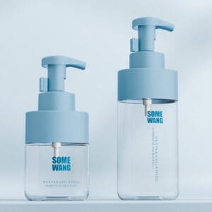 Two blue-lidded clear pump bottles (300ml/500ml PET plastic) are displayed on a light blue background, highlighting their sleek design.