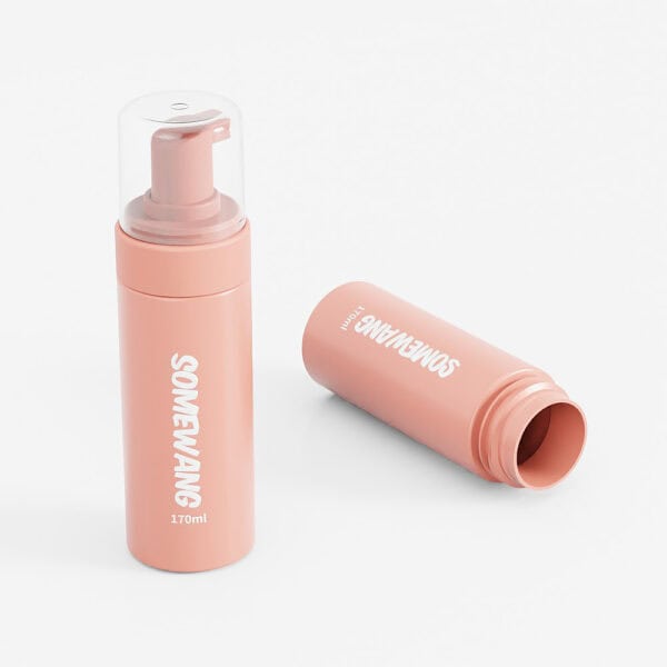 Two peach-colored PET foam brush bottles, one upright with a pump, the other horizontal capless; both display "SOMEWAN" for stylish use.