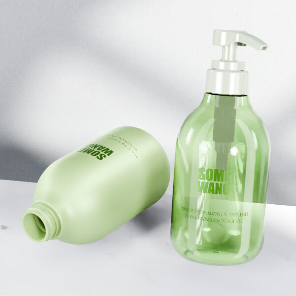 Dos botellas PET de 500 ml de color verde con forma de pera para champú: una en posición vertical con bomba y otra de lado sin tapa sobre una superficie clara.