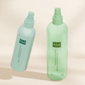 Dua botol semburan PET 360ml, hijau muda dan biru. Tahan lama, mudah alih, untuk penjagaan kesihatan semasa dalam perjalanan. Latar belakang beige.