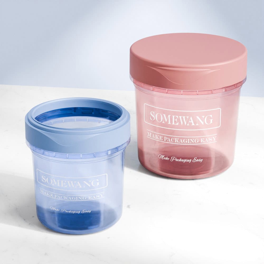 Two 240ML/480ML/600ML pp transparent frosted jars with lids, one blue and one pink, labeled "somewang make packaging easy," on a marble surface.