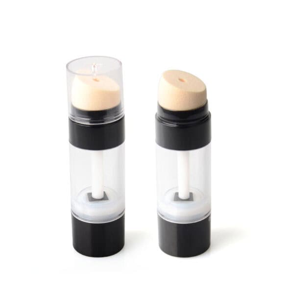 Two clear cylindrical containers with black bases and beige sponge applicators, one capped. Both could be 30g concealer highlighter sticks.