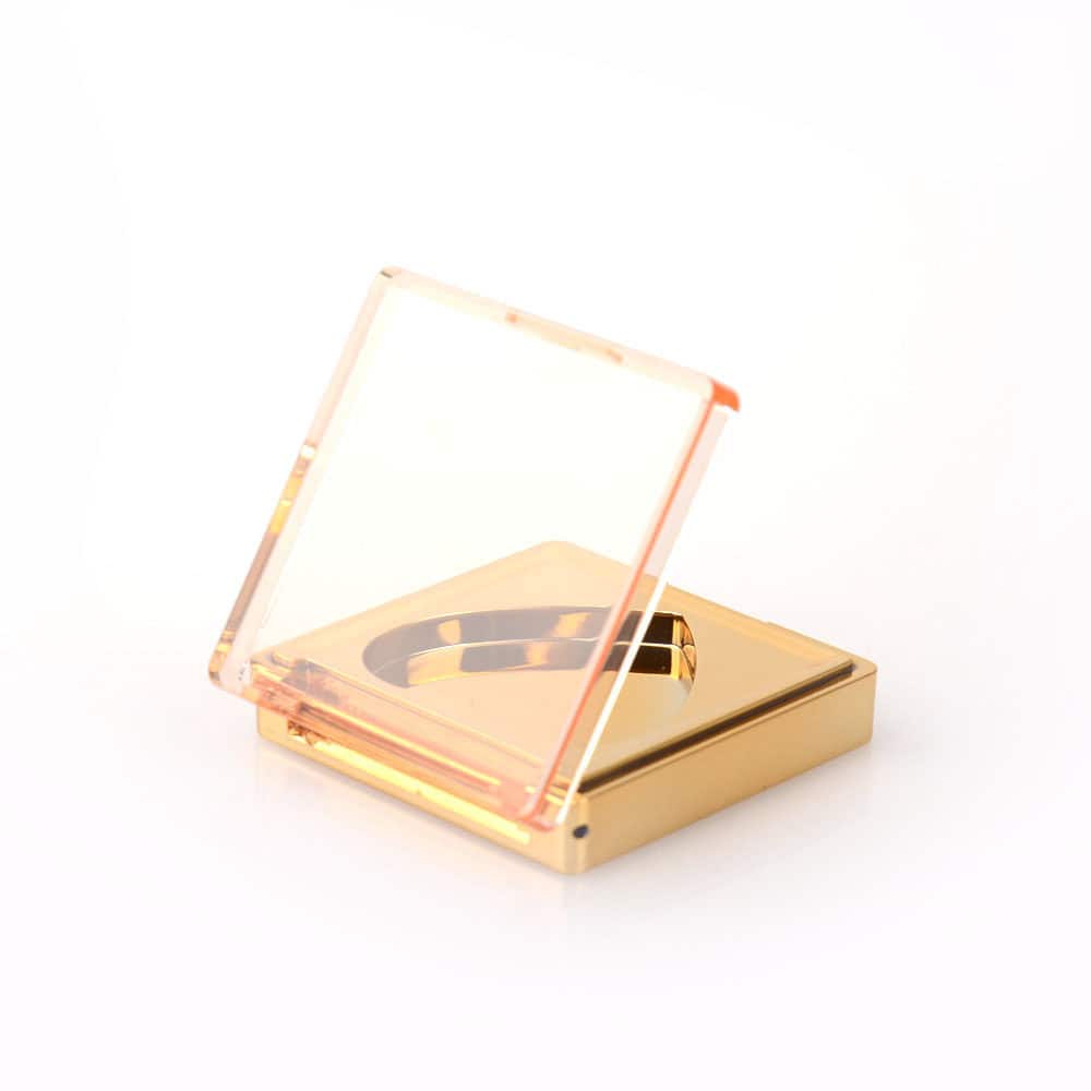 A slightly open SWC-CMF024 square gold blush case with a transparent hinged lid and built-in mirror against a white background.