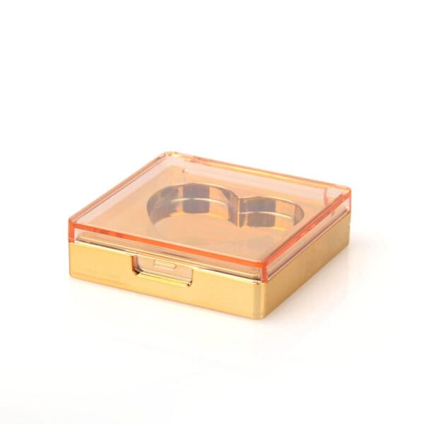 This SWC-CMF024 blush case, a small golden square box with an orange-tinted lid and heart-shaped compartment, offers elegance and function.