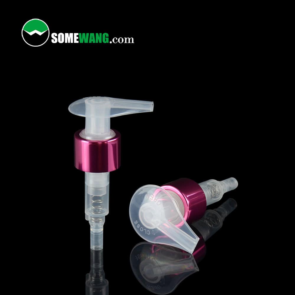 Two 24/410 PP lotion pumps with pink metallic collars on a black reflective surface, "SOMEWANG.com" text in the corner. Elegant aluminum finish.