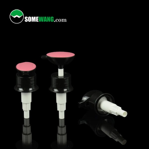 Three black & white dispensers with pink tops, 32mm lotion pumps. One lying down on a black reflective surface with "SOMEWANG.com" logo.