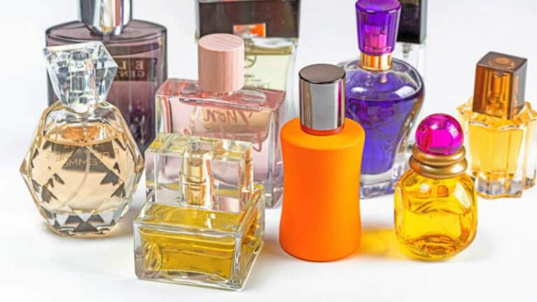 Various colorful perfume bottles in different shapes and sizes are arranged on a white surface.