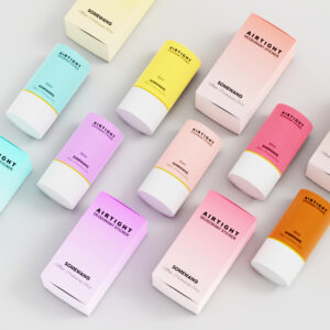 Hộp và chai màu pastel có nhãn "AIRTIGHT" và "SOMEHWANG", bao gồm cả que khử mùi 30ml, trên bề mặt sáng.