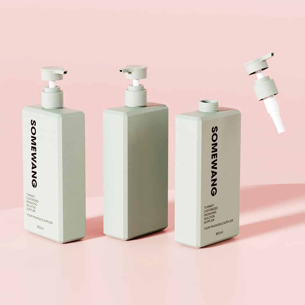 Three light green 960ml square Somewang PET shampoo bottles sit on a pink background, two with pumps secured and one detached.