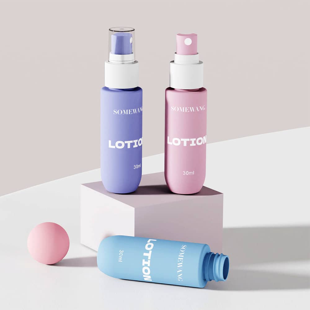 Three 30ml PET mist sprayer bottles (blue/pink, upright and lying down) are on a white block—sleek, colorful packaging.