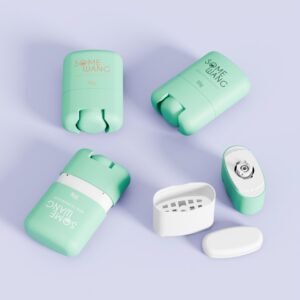 Empat bekas deodoran "SOME WANG" hijau pastel dan putih, dua terbuka, pada permukaan ungu muda.