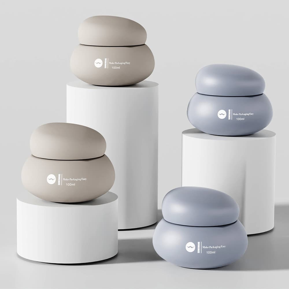 Four rounded jars with pebble lids in beige and blue sit on white pedestals, showcasing Somewang's elegant packaging.
