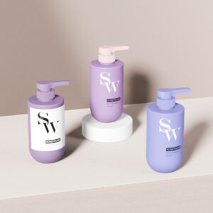 "SW" 라벨과 로션 펌프가 붙은 300ml PE 병 3개가 나무와 흰색 스탠드 위에 정리되어 있어 샴푸에 이상적입니다.