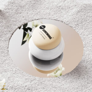 Um frasco PET redondo com textura de seixo fica sobre um espelho, refletindo flores e seu design exclusivo.