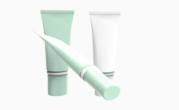 Три косметических тюбика — два вертикальных (мятно-зеленого и белого цветов) и один мятно-зеленый, наклоненный вперед, на белом фоне.